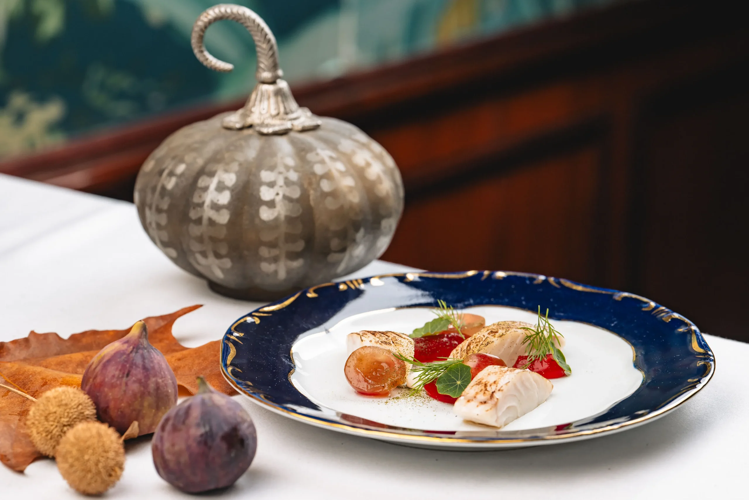Pike-perch marinated in verjus, served with marinated grapes and sour cream, on a blue-rimmed Gundel plate